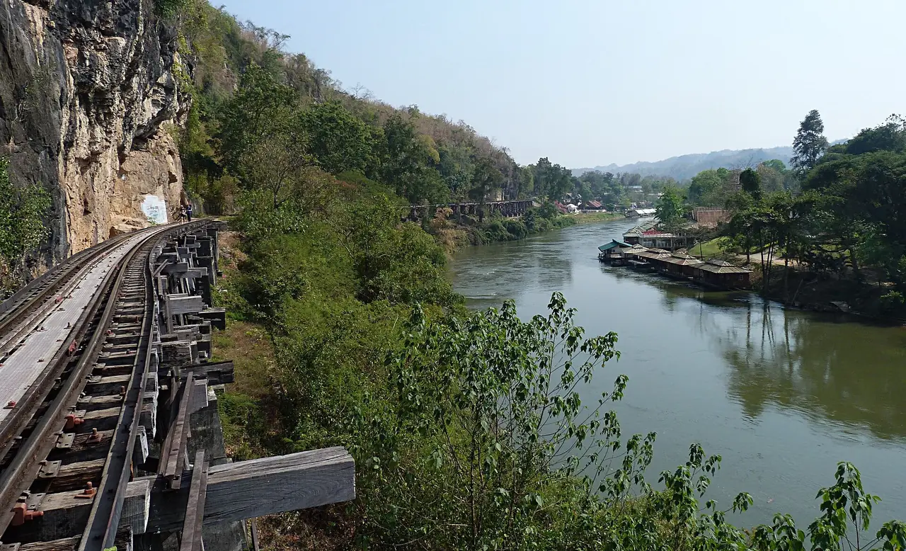 รางรถไฟสายมรณะริมแม่น้ำแควเมื่อมองไปทางถ้ำกระแซ ภาพถ่ายจาก Wikimedia Commons
