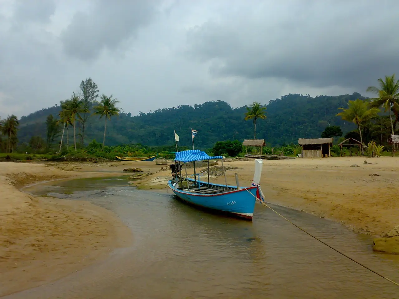 เรือหางยาวบนหาดบางเนียง ภาพของ Bjoertvedt จาก Wikimedia Commons ไม่ได้ระบุปีที่ถ่าย