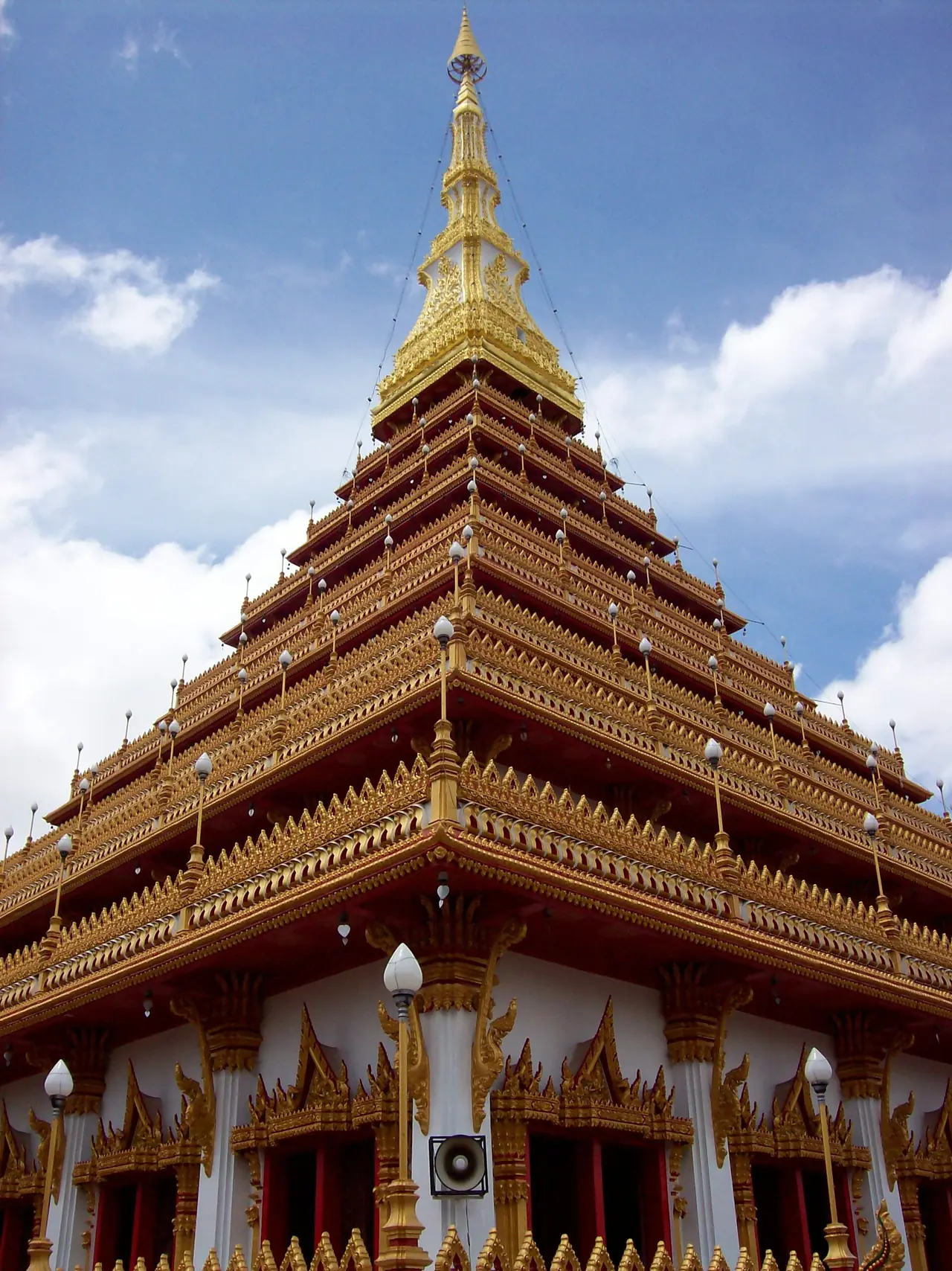 พระธาตุเก้าชั้นมองจากด้านล่าง เห็นหลังคาซ้อนชั้นสีทองและฐานสีขาว ภาพถ่ายจาก Wikimedia Commons