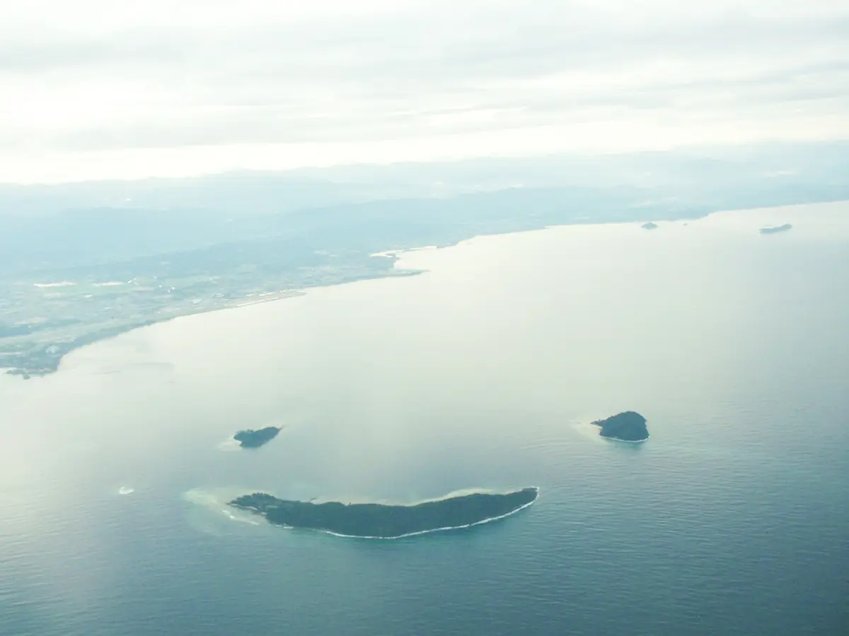 ภาพถ่ายทางอากาศของเกาะมานูกัน มามูติก และสุลุก ที่มองเห็นเป็นแถวเกาะเล็กเหนือผืนทะเล (ภาพประกอบตำแหน่งเกาะ)