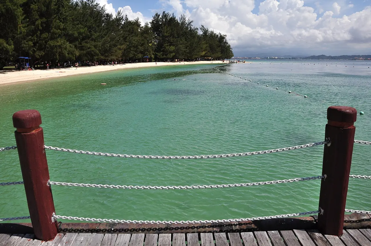 น้ำทะเลสีเขียวและทางไม้ริมท่าเรือบนเกาะมานูกัน มองไปทางเมืองโคตาคินาบาลู (ภาพบรรยากาศ)