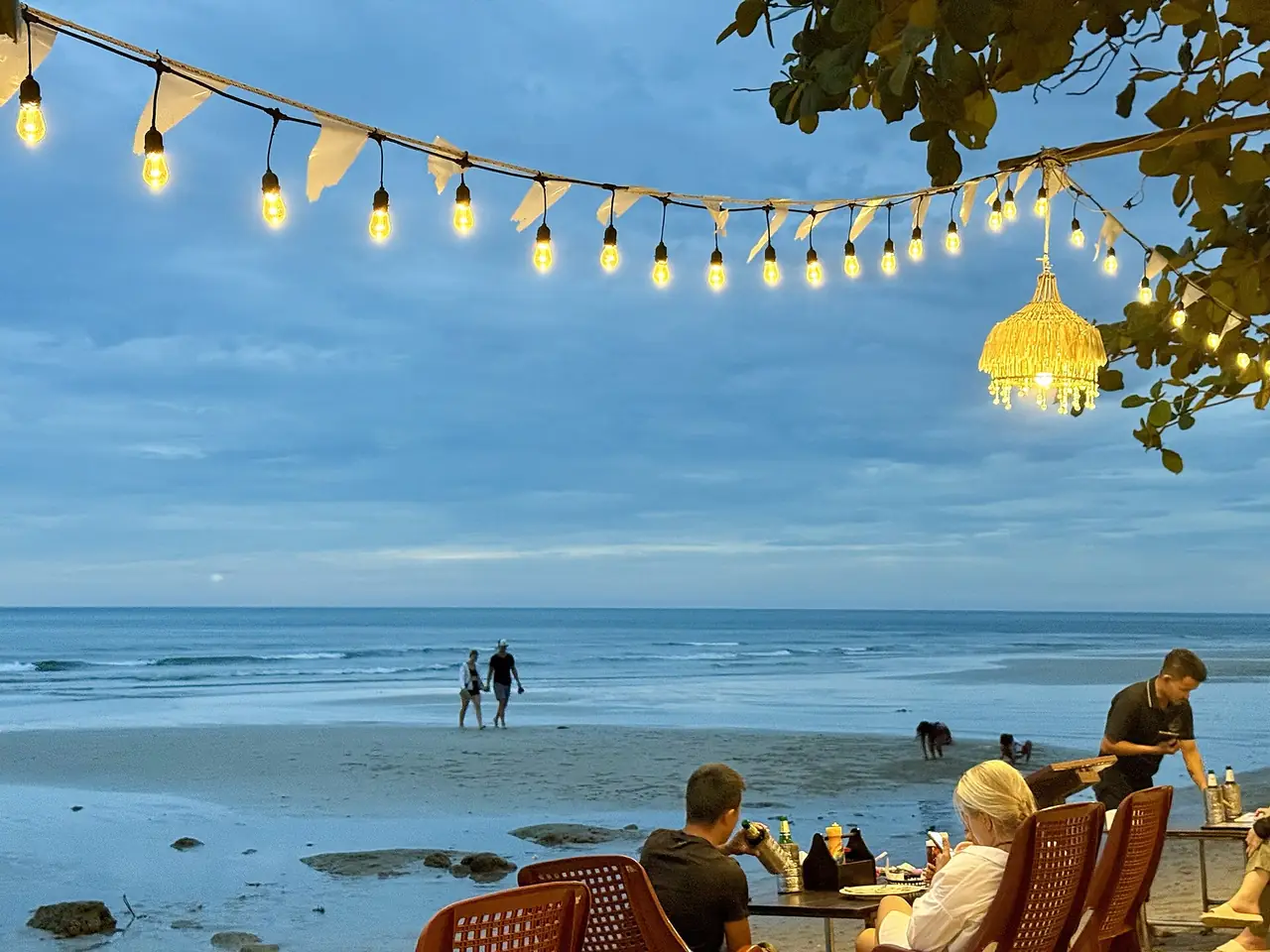 บรรยากาศยามค่ำที่หาดทรายขาว เกาะช้าง มีไฟประดับร้านริมหาดและคนเดินเล่นริมน้ำ ภาพของ Slyronit จาก Wikimedia Commons