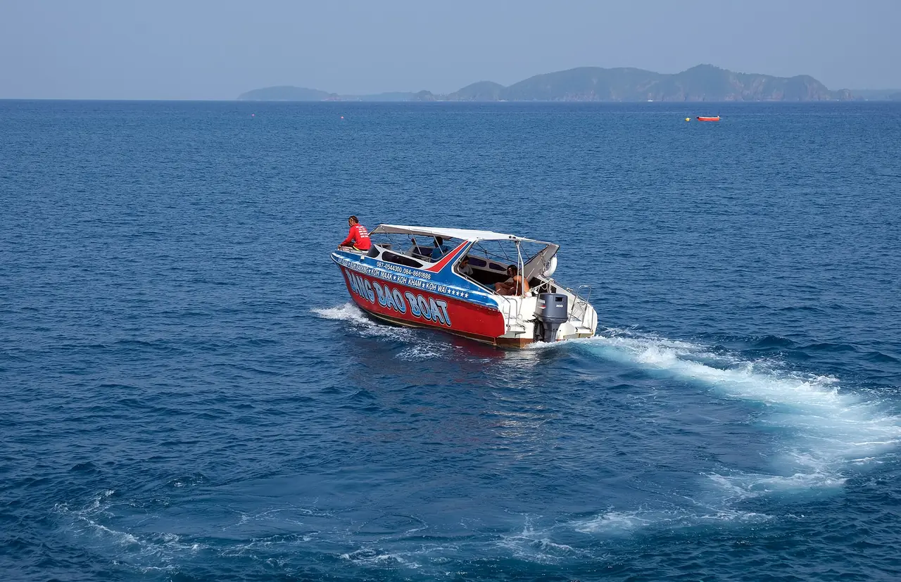 สปีดโบ๊ตสีแดงขาวแล่นกลางทะเลใกล้เกาะรัง ตามคำบรรยายภาพบน Commons เป็น Bang Bao Boat ภาพประกอบเรือเที่ยวที่วิ่งในพื้นที่เกาะช้างและเกาะรัง ไม่ได้ระบุว่าเป็นเรือไปเกาะกูด ภาพของ kallerna จาก Wikimedia Commons
