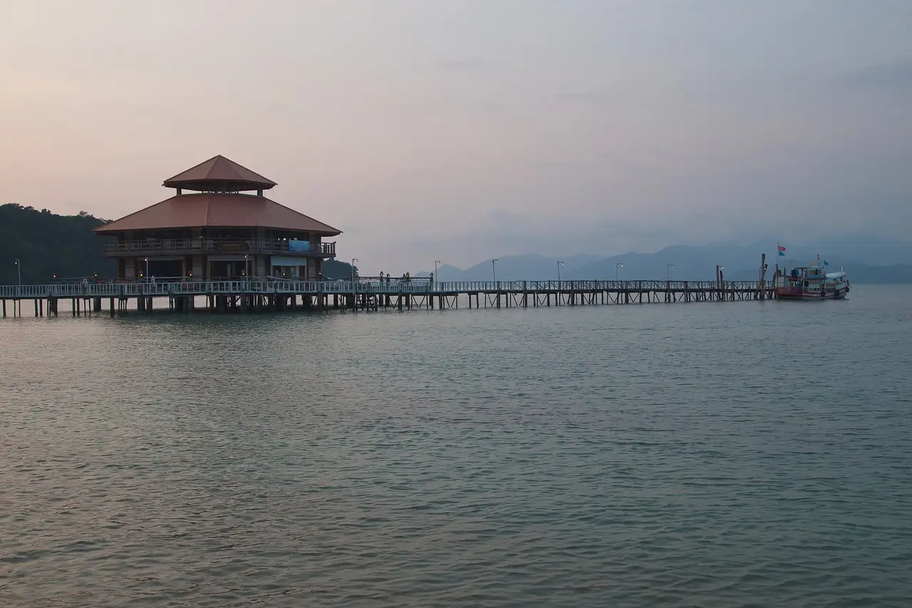 ท่าเรือไม้ยาวและอาคารปลายท่าตอนพลบค่ำบนเกาะหวาย ตามคำบรรยายภาพบน Commons อาคารนี้เป็นศูนย์ข้อมูลของอุทยานแห่งชาติหมู่เกาะช้าง ภาพของ Vyacheslav Argenberg จาก Wikimedia Commons