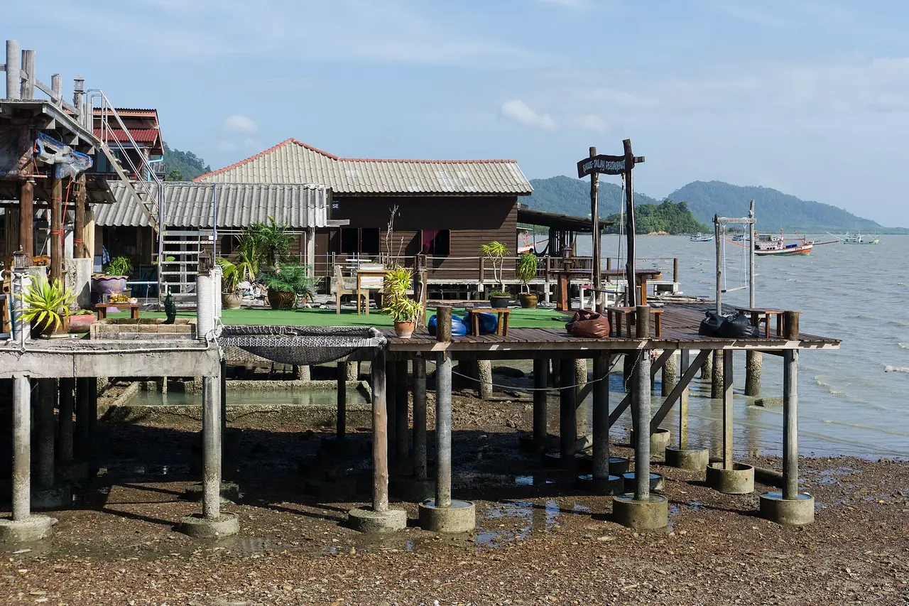 บ้านยกพื้นและศาลาไม้ริมน้ำในเมืองเก่าลันตา ตอนน้ำลง ภาพถ่ายจาก Wikimedia Commons