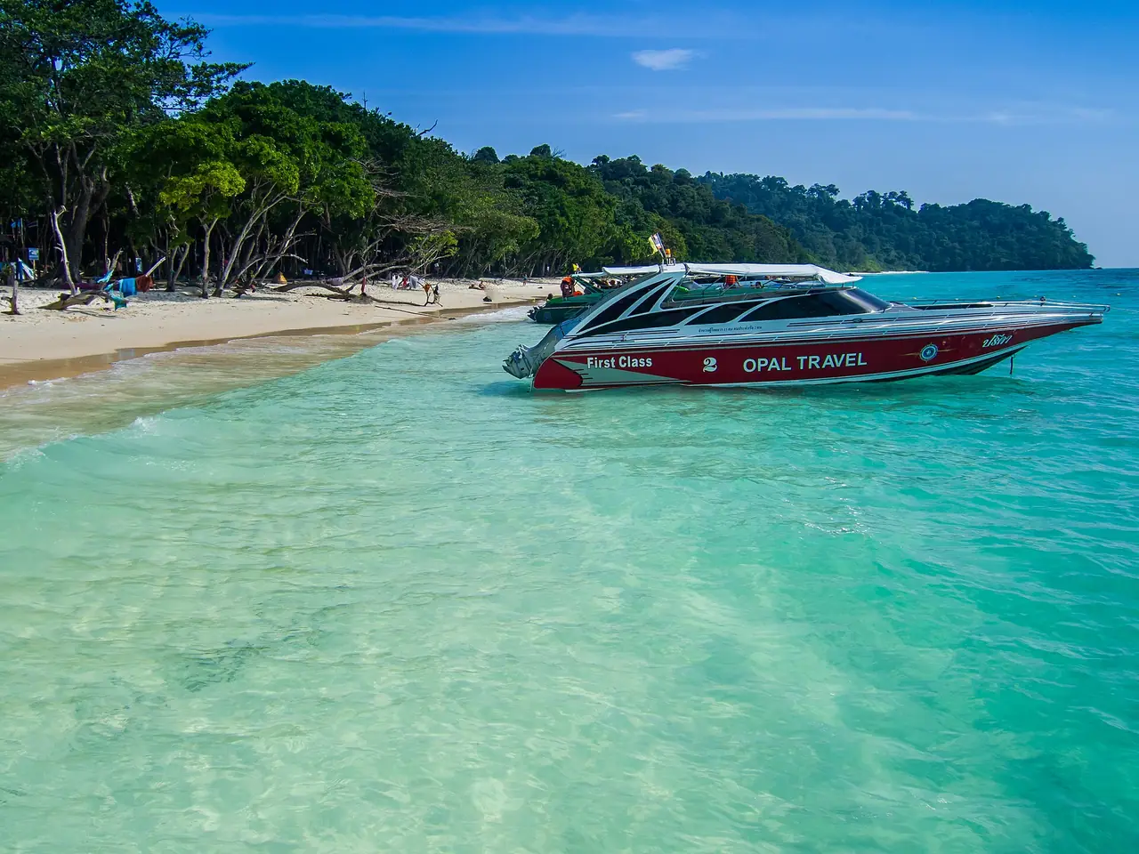 เรือสปีดโบ๊ตจอดหน้าหาดเกาะรอก น้ำทะเลสีเขียวใส ภาพถ่ายจาก Wikimedia Commons