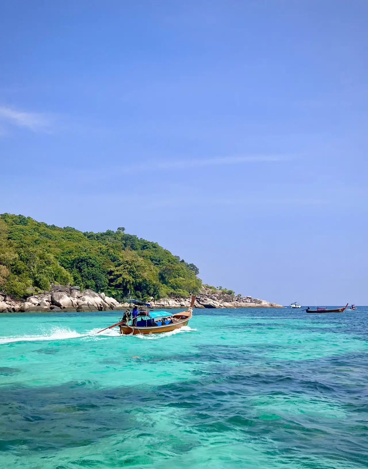 เรือหางยาวแล่นผ่านน้ำสีเทอร์ควอยซ์ใกล้เกาะหลีเป๊ะ ภาพจาก Wikimedia Commons ผู้ถ่าย Sharon Hahn Darlin ปี 2568