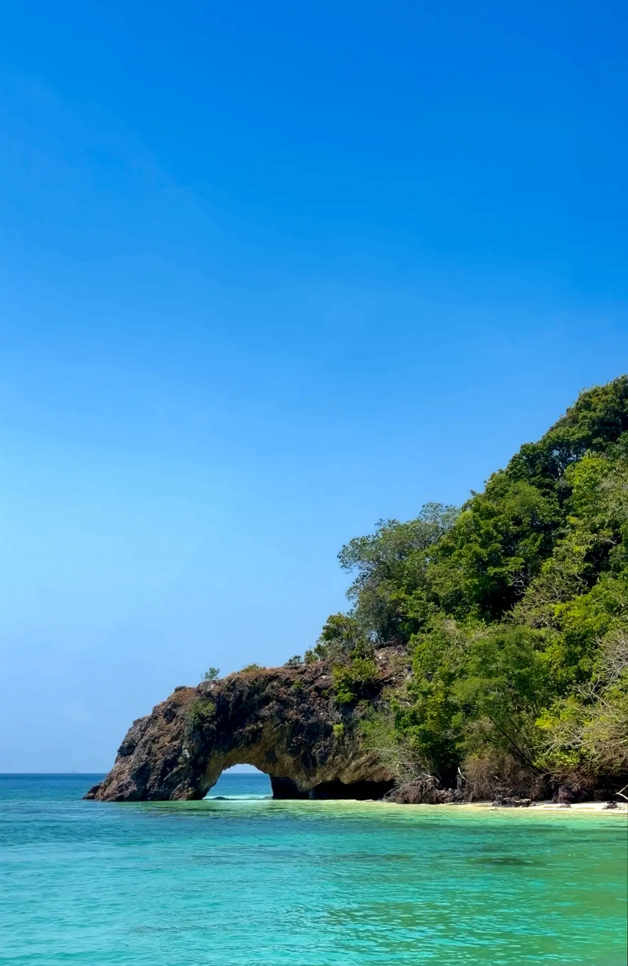 ซุ้มหินโค้งริมทะเลสีฟ้าในเขตอุทยานตะรุเตา ผู้ถ่ายตั้งชื่อภาพว่า Gateway to Tarutao และไม่ระบุว่าเป็นเกาะใด ภาพจาก Wikimedia Commons ผู้ถ่าย Anustria