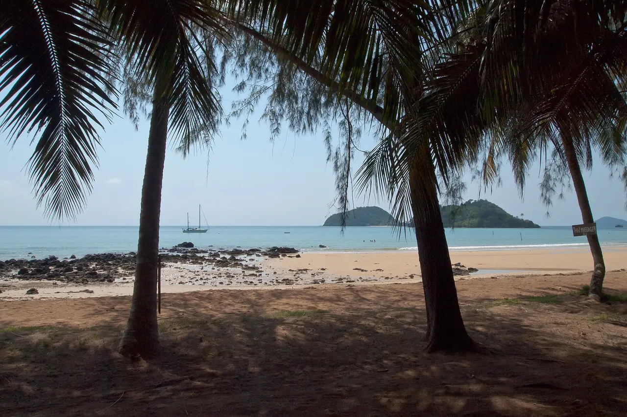 ต้นมะพร้าวเงามืดและหาดทรายที่มีเกาะเล็กอยู่ไกล ๆ บนเกาะหมาก ภาพของ Vyacheslav Argenberg จาก Wikimedia Commons ตามคำบรรยายภาพบน Commons ไม่ระบุชื่ออ่าว