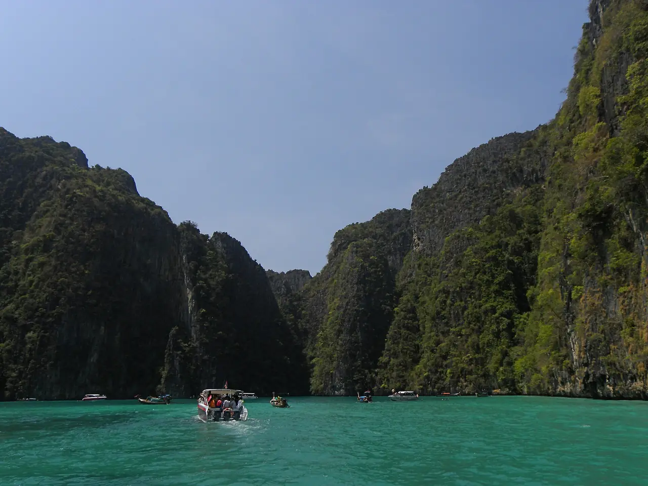 เรือนำเที่ยวเข้าอ่าวปิเละ ผาหินสูงล้อมน้ำสีเขียวมรกต ภาพถ่ายจาก Wikimedia Commons