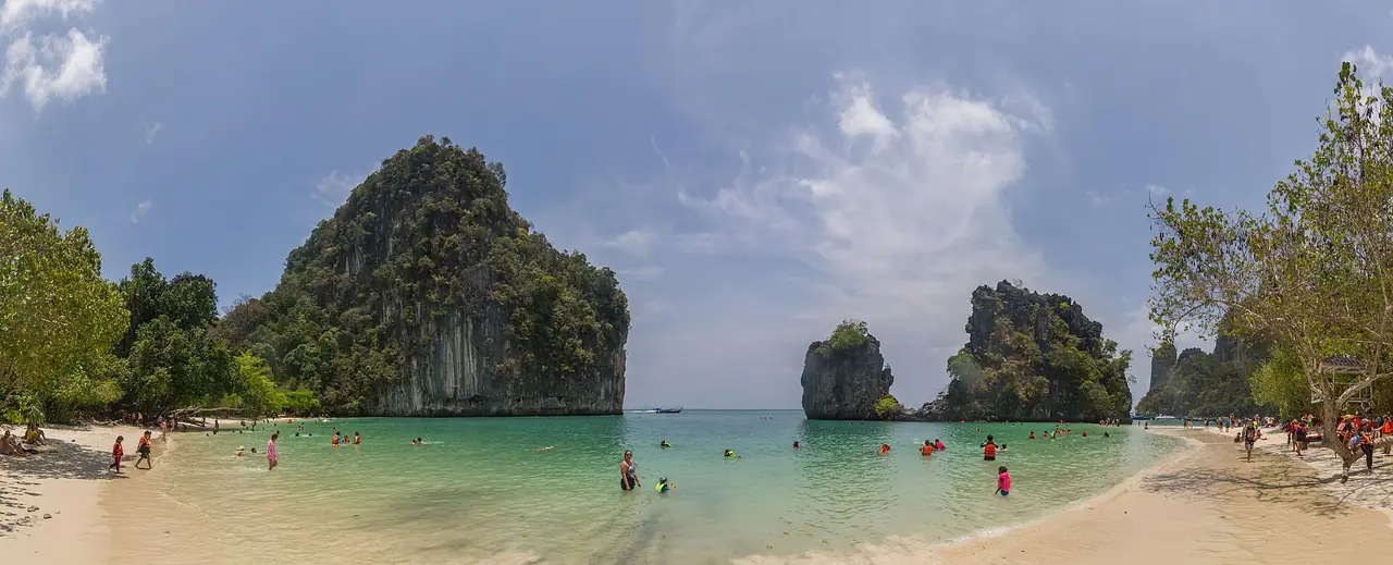 ภาพพาโนรามาของหาดทรายและน้ำเขียวใสหน้าผาหินปูนที่เกาะห้อง มีคนเล่นน้ำตามชายหาด ภาพของ Maksym Kozlenko จาก Wikimedia Commons ถ่ายเมื่อ 12 เม.ย. 2559 ตามคำบรรยายภาพบน Commons เป็นหาดบนเกาะห้อง ในหมวด Tourism in Krabi Province และ Beaches of Ao Phang Nga National Park
