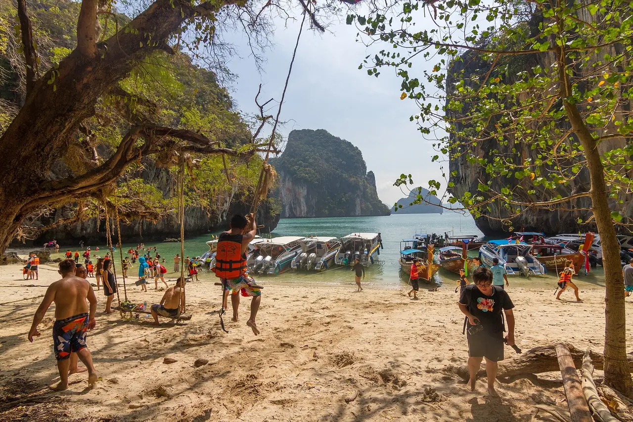 ชายหาดที่เกาะละเลาลาดิง มีชิงช้าเชือกใต้ต้นไม้ นักท่องเที่ยวสวมเสื้อชูชีพ และเรือเร็วหลายลำจอดอยู่ริมหาด ภาพของ Maksym Kozlenko จาก Wikimedia Commons ถ่ายเมื่อ เม.ย. 2559 ภาพเก่า จำนวนคนเปลี่ยนตามวันและฤดู