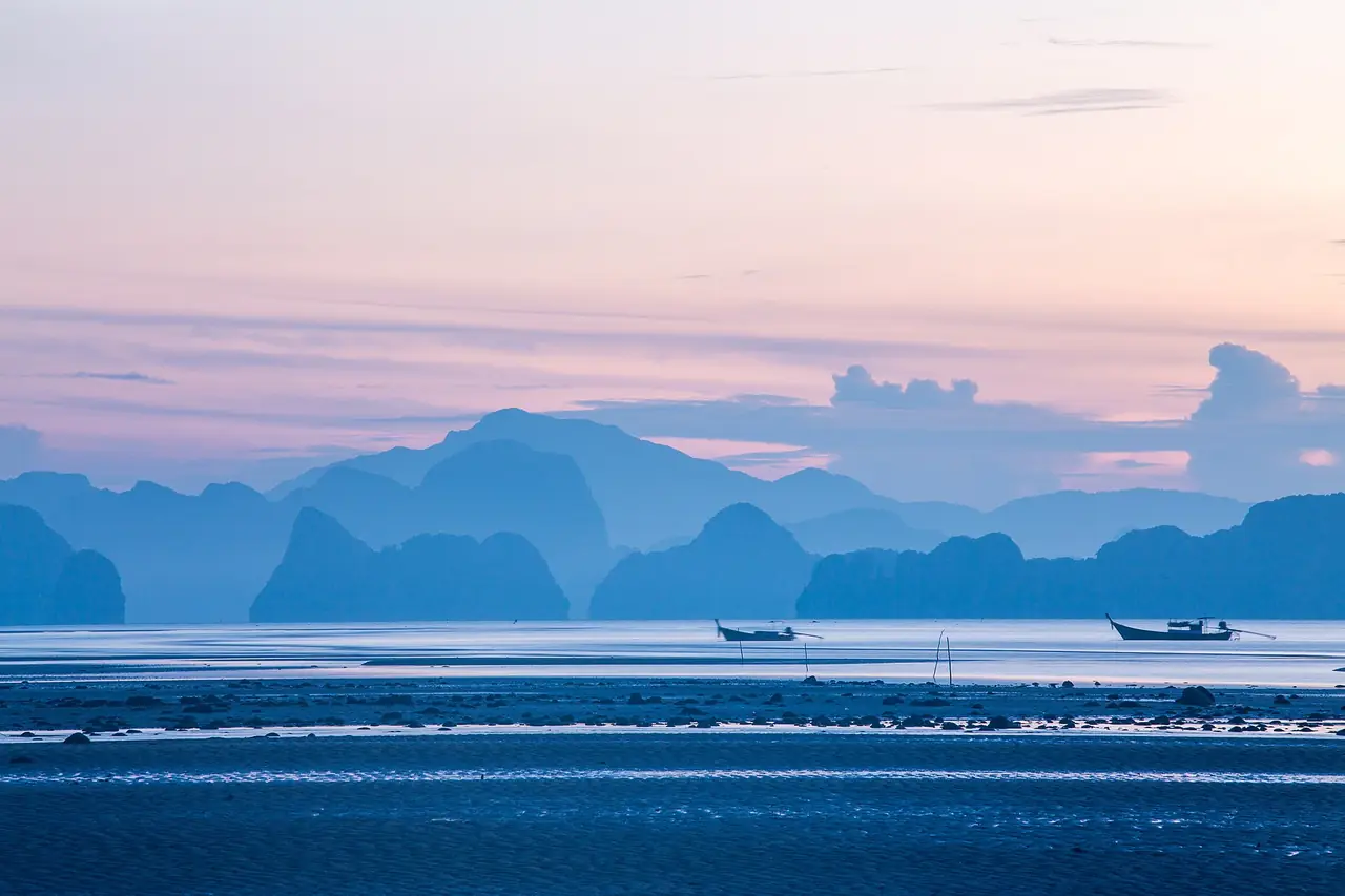 แสงเช้าเหนือหมู่เกาะหินปูนและเรือหางยาวกลางน้ำ ภาพของ Phapoom จาก Wikimedia Commons ถ่ายเมื่อ 26 ต.ค. 2560 ตามคำบรรยายภาพบน Commons เป็นพระอาทิตย์ขึ้นที่หมู่เกาะห้อง
