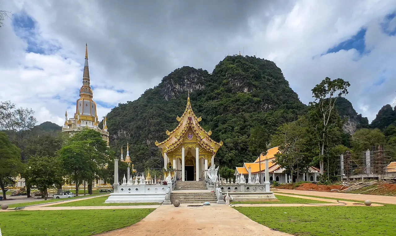 ศาลาและเจดีย์ในบริเวณวัดด้านล่าง มีภูเขาหินปูนเป็นฉากหลัง ภาพถ่ายจาก Wikimedia Commons