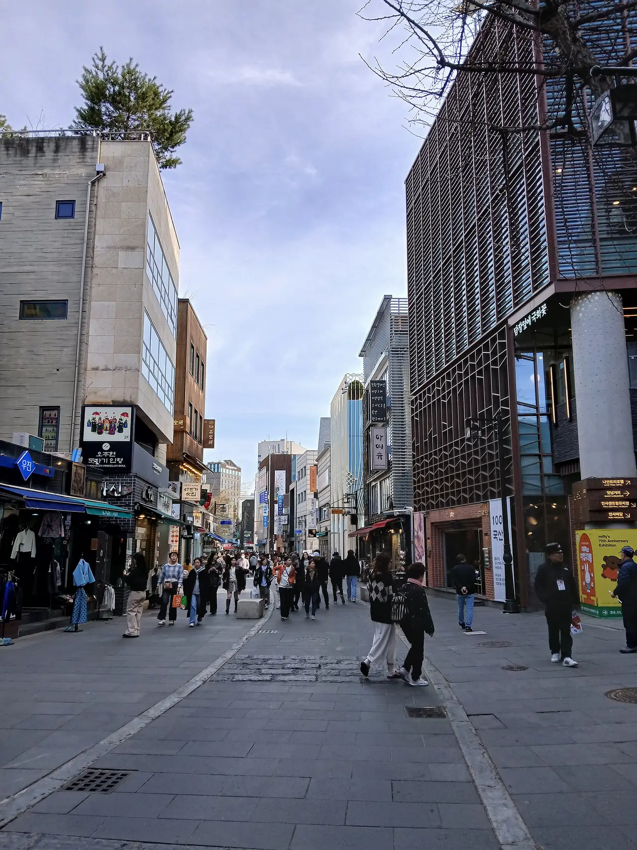 ถนนอินซาดงกิล (Insadong-gil) ภาพเดือนมีนาคม 2568 มีร้านค้าและคนเดินสองข้างทาง ภาพจาก Wikimedia Commons ผู้ถ่าย Epicgenius สัญญา CC BY-SA 4.0