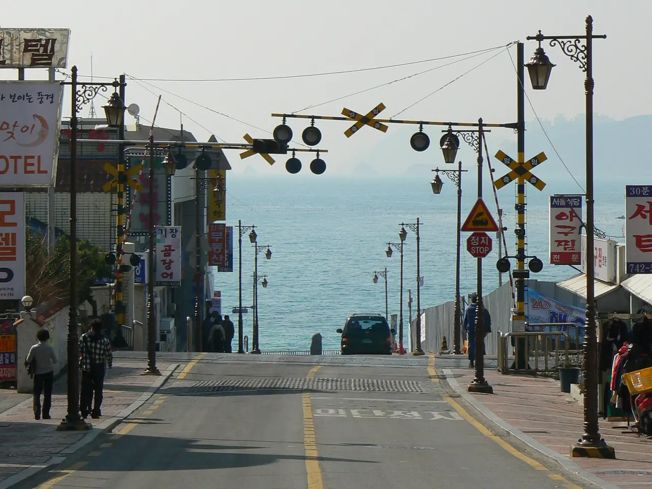 ถนนในย่านมีโพปลายหาดแฮอุนแด มีเครื่องหมายทางรถไฟสายเก่าที่ปัจจุบันเป็นจุดเริ่มของ Blue Line Park ภาพเก่าก่อนปรับปรุง ปีที่ถ่ายไม่ระบุ ภาพจาก Wikimedia Commons ผู้ถ่าย hangidan สัญญา CC BY-SA 2.0