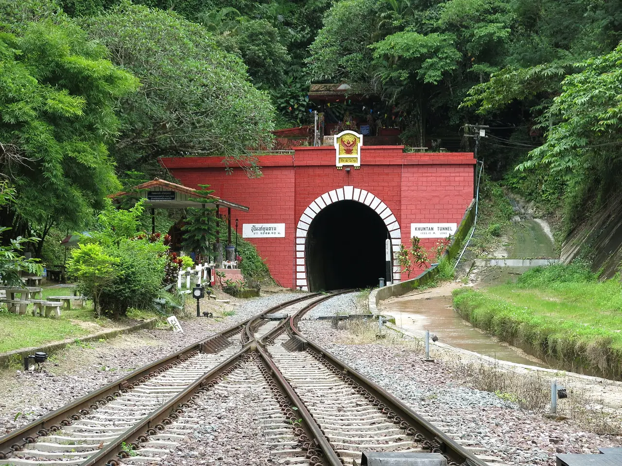 The north-western portal of the Khun Tan tunnel, with the railway tracks and a red arch