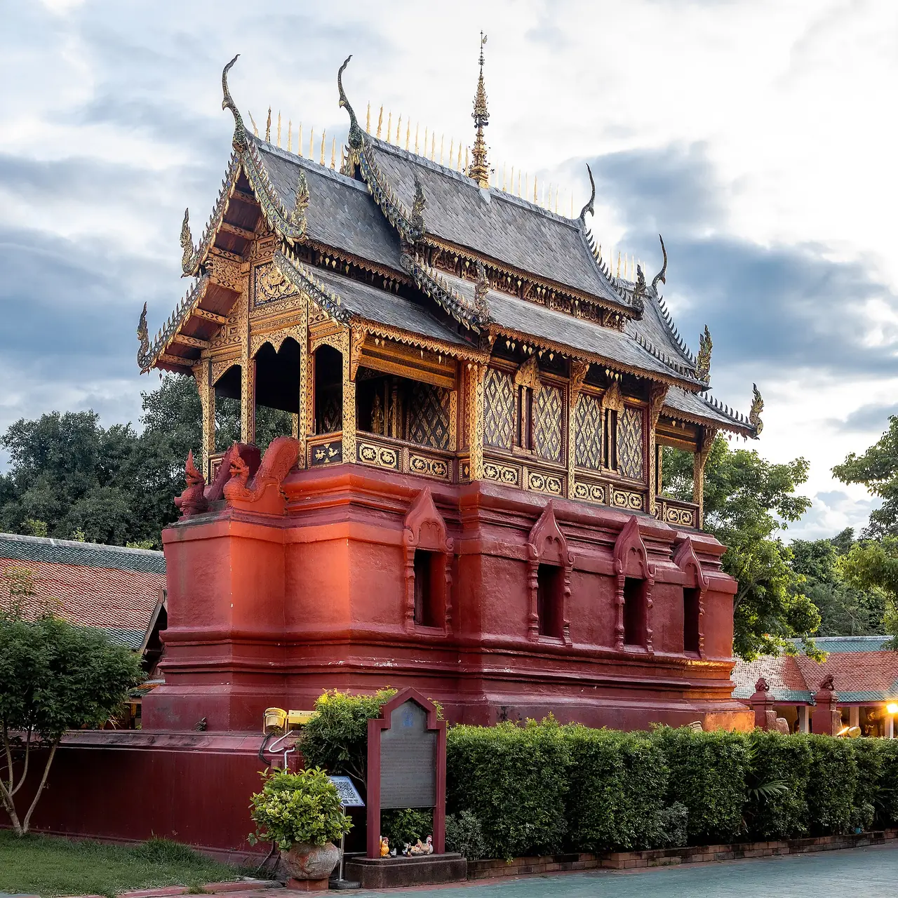หอสีแดงหลังคาไม้ซ้อนชั้นประดับทองในบริเวณวัดพระธาตุหริภุญชัย ภาพของ Supanut Arunoprayote จาก Wikimedia Commons ตามชื่อไฟล์ระบุว่าเป็นหอไตร