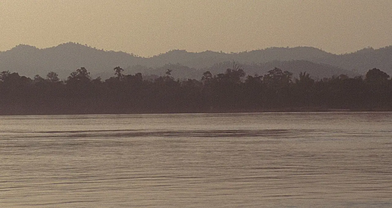 แม่น้ำโขงยามพลบค่ำ มีแนวเขาฝั่งตรงข้ามอยู่ไกลออกไป ภาพถ่ายจาก Wikimedia Commons