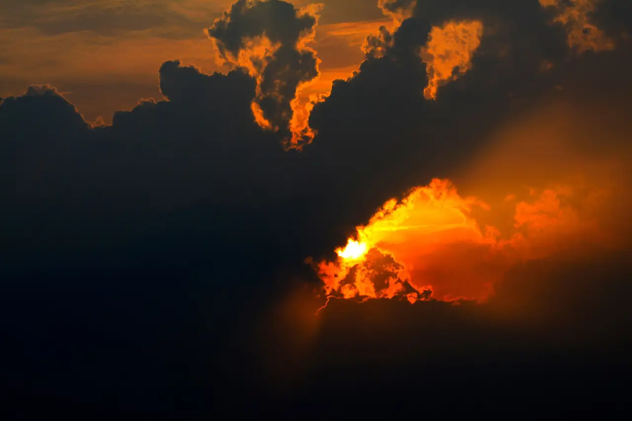 ก้อนเมฆมืดและแสงสีส้มเมื่อพระอาทิตย์ตกในภูสวนทราย ภาพถ่ายจาก Wikimedia Commons