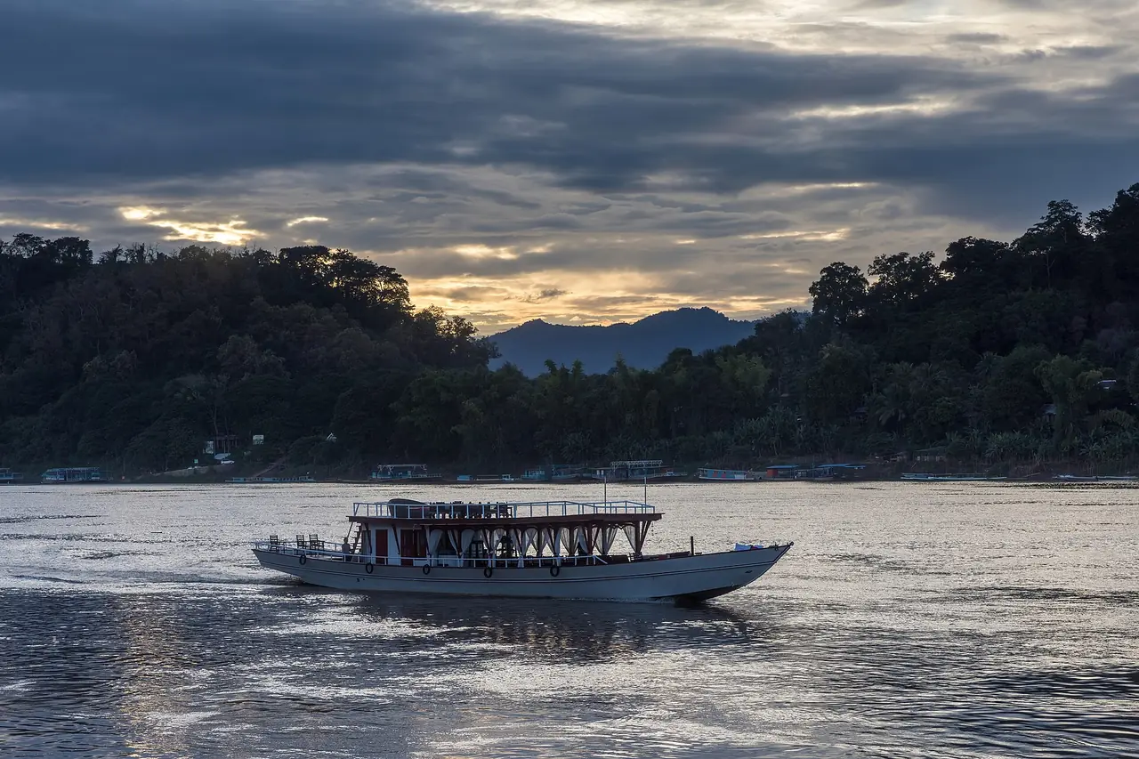 เรือบนแม่น้ำโขงตอนพระอาทิตย์ตกที่หลวงพระบาง (ภาพบรรยากาศ ไม่ใช่เรือทัวร์ของผู้ให้บริการรายใด)