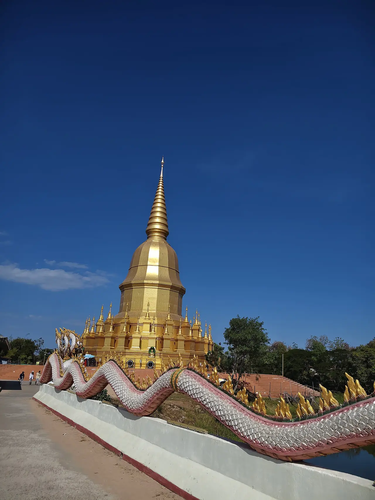 เจดีย์สีทองและราวบันไดนาคที่วัดป่าวังน้ำเย็น อำเภอเมืองมหาสารคาม ภาพของ Wiraphat Raksat จาก Wikimedia Commons ใบอนุญาต CC BY 4.0 ถ่ายเมื่อ 25 ม.ค. 2569 คำอธิบายบน Commons ระบุเพียงชื่อวัด ไม่ระบุว่าเป็นมหาเจดีย์ศรีมหาสารคามตามที่ อบจ.กล่าวถึง