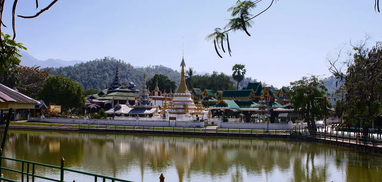 วัดจองคำและจองกลางสะท้อนผิวน้ำหนองจองคำ ยามกลางวันท้องฟ้าโปร่ง ภาพถ่ายจาก Wikimedia Commons
