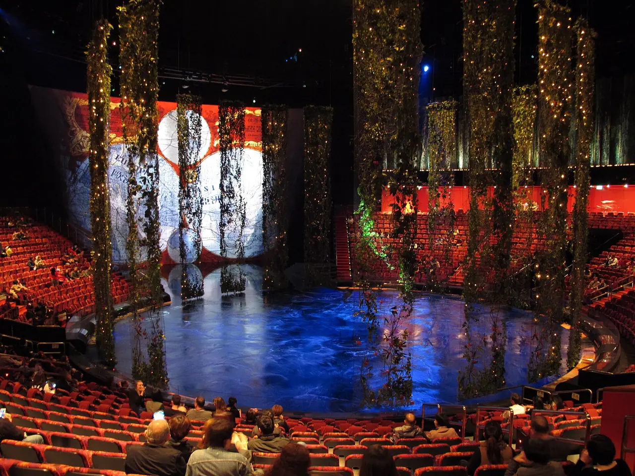 เวทีสระน้ำและม่านไม้เลื้อยในโรงละครของ House of Dancing Water ภาพจาก Wikimedia Commons ผู้ถ่าย Wing1990hk ปี 2556 สัญญา CC BY 3.0 เป็นภาพของโชว์ชุดเดิมก่อนปรับใหม่