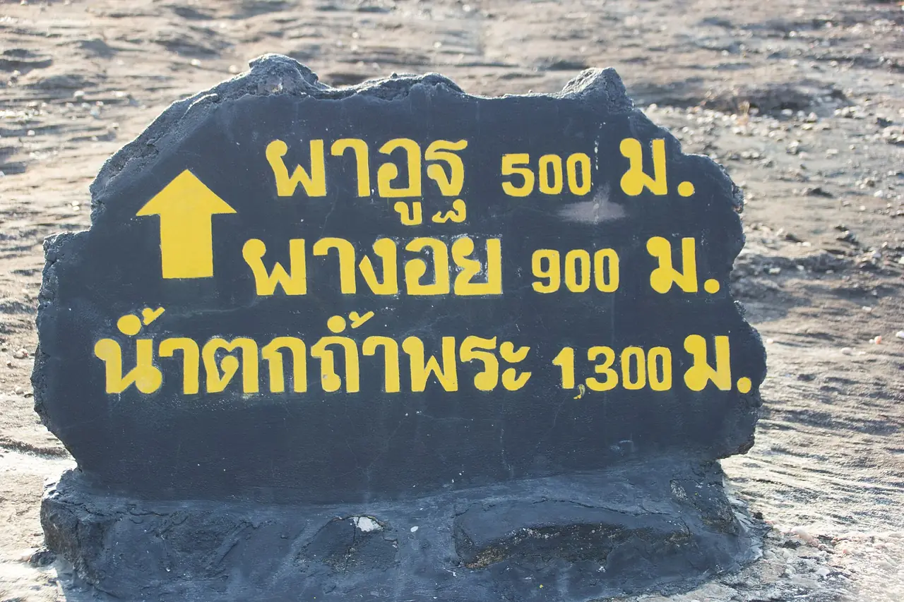 ป้ายในอุทยานบอกระยะ ผาอูฐ 500 ม. ผางอย 900 ม. น้ำตกถ้ำพระ 1,300 ม.