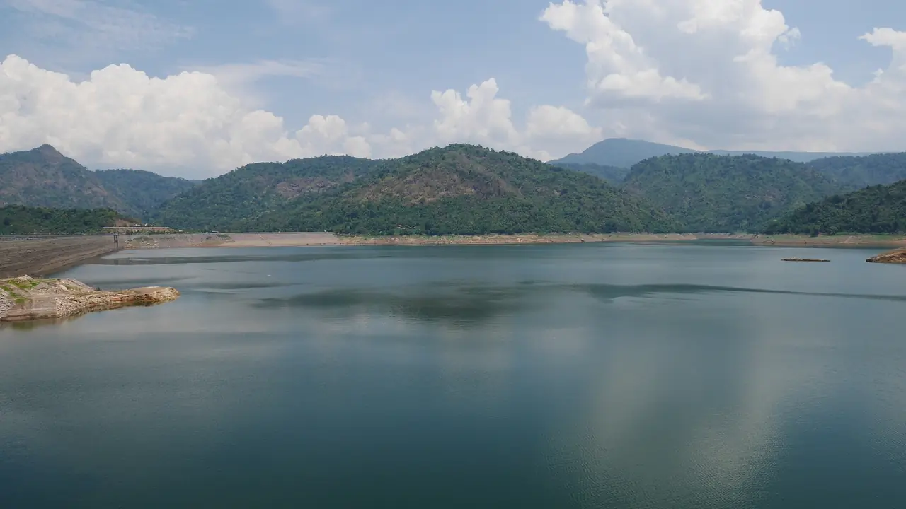 The Khun Dan Prakarn Chon reservoir seen from the dam, with forested hills across the water