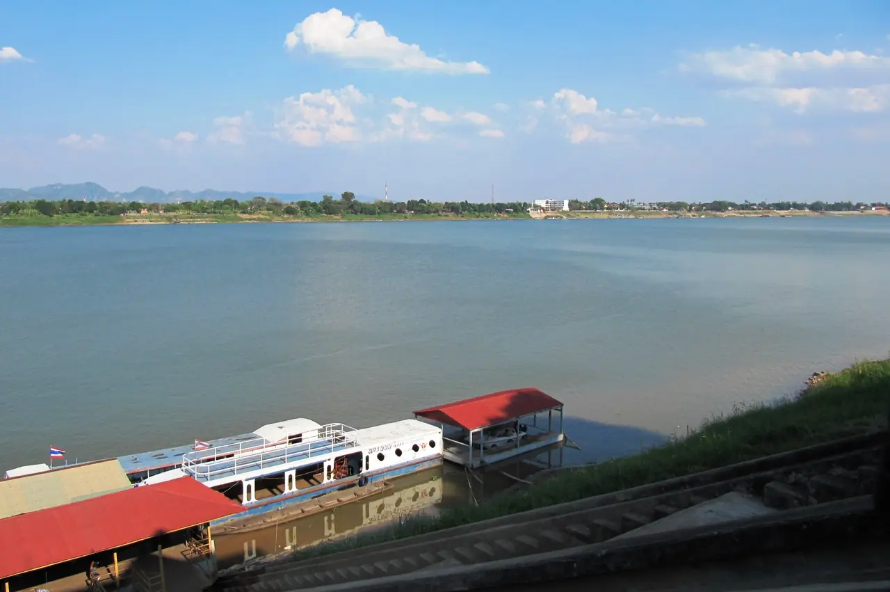 เรือท่องเที่ยวริมตลิ่งแม่น้ำโขง มองข้ามไปยังเมืองท่าแขกของลาว