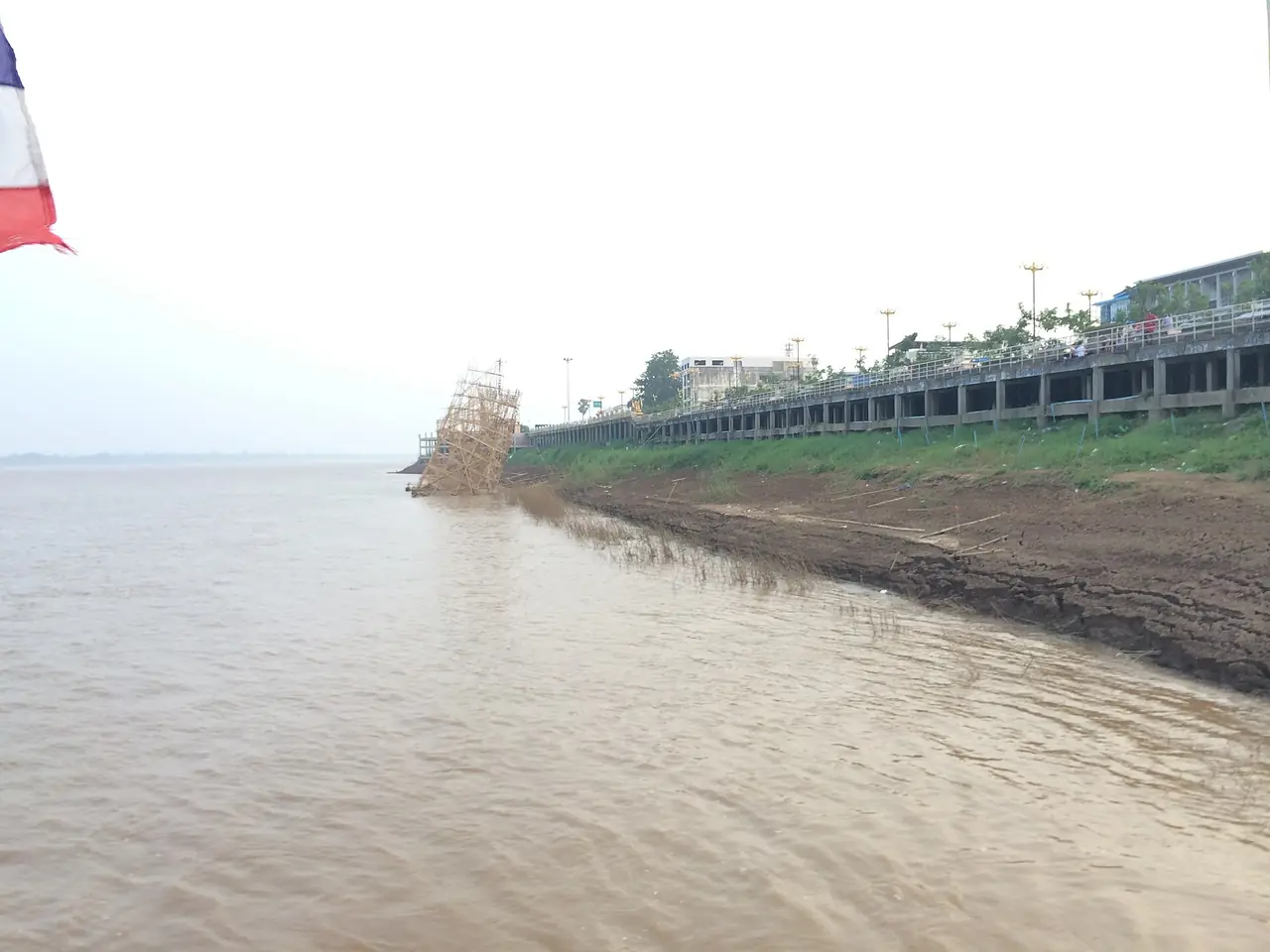 ฝั่งโขงในเขตในเมือง นครพนม มีเขื่อนริมแม่น้ำอยู่ด้านขวา ภาพของ กิตติ เลขะกุล จาก Wikimedia Commons ภาพนี้ไม่ใช่ภาพงานไหลเรือไฟ