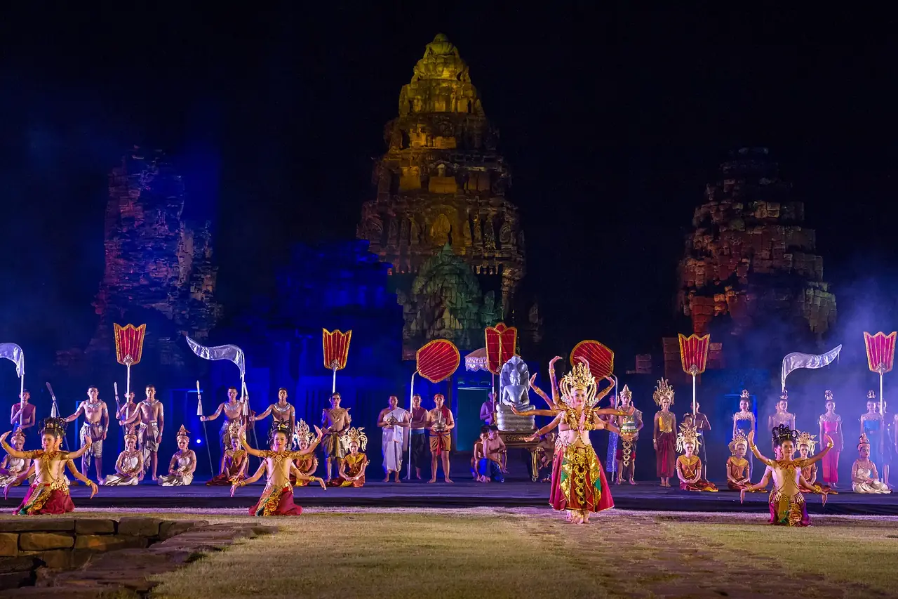 การแสดงนาฏศิลป์ยามค่ำคืนหน้าปราสาทหินพิมายที่มีไฟส่องหลายสี ภาพถ่ายจาก Wikimedia Commons