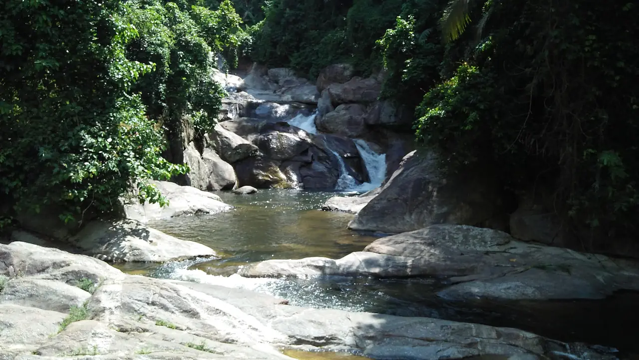 Wang Mai Pak waterfall tumbling over rocks into a pool in Lan Saka district
