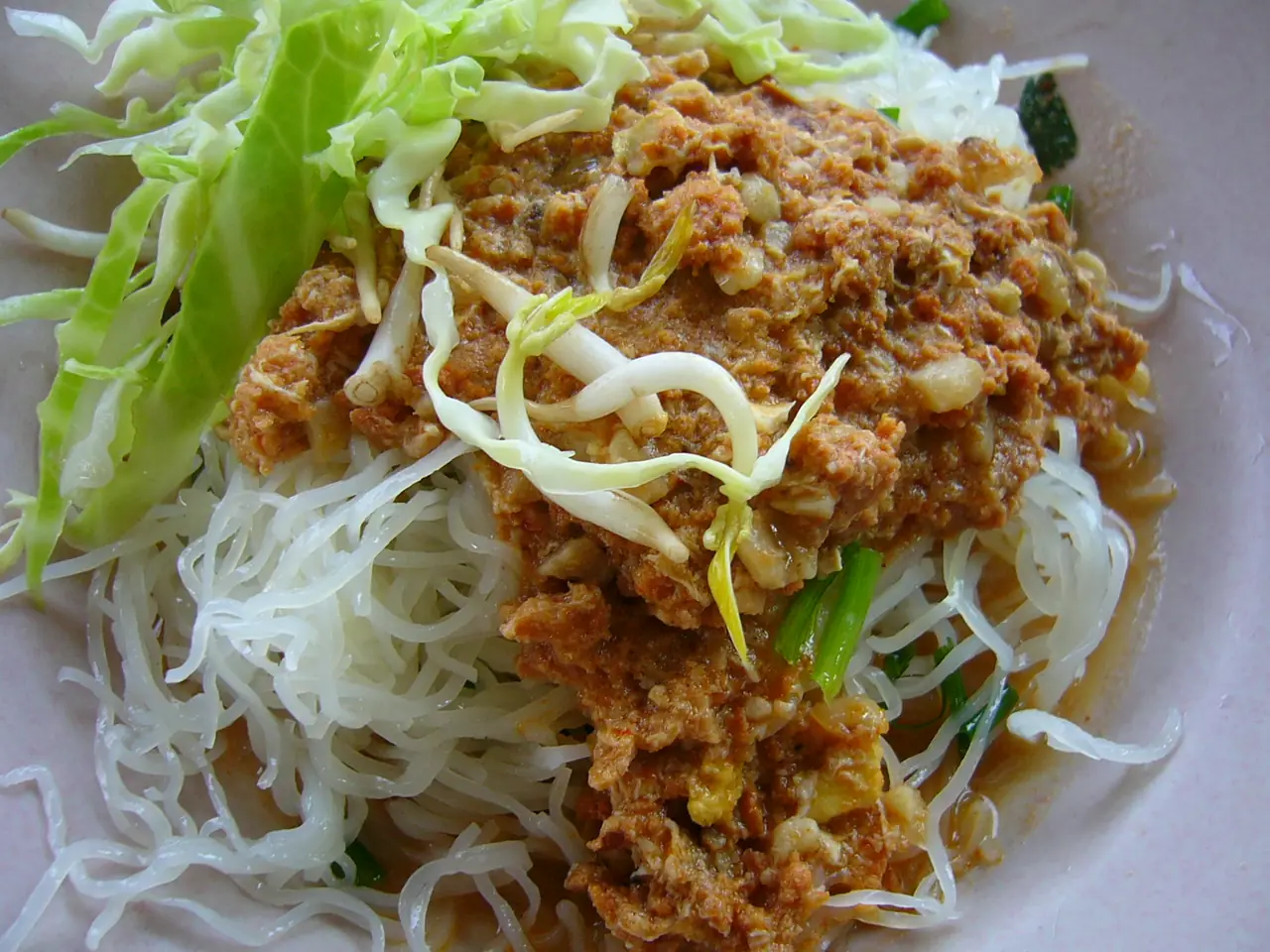 ขนมจีนน้ำยาที่โรยหน้าด้วยผักสดและน้ำยาเนื้อปลา ภาพของ Mattes จาก Wikimedia Commons ไม่ได้ถ่ายที่นครศรีธรรมราช ตามคำอธิบายไฟล์เป็นภาพประกอบเมนูทั่วไป