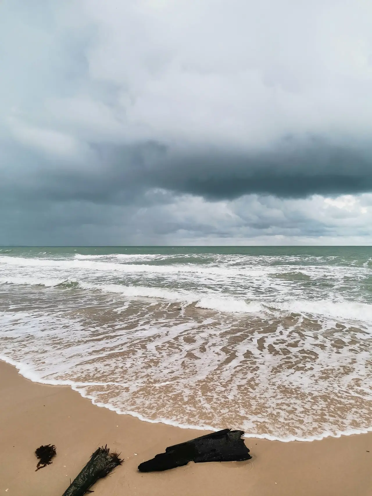 ชายหาดและคลื่นใต้ท้องฟ้าครึ้มที่หาดขนอม ถ่ายเมื่อเย็นวันที่ 5 พ.ค. 2565 ตามคำอธิบายไฟล์ ภาพของ OraMAAG จาก Wikimedia Commons