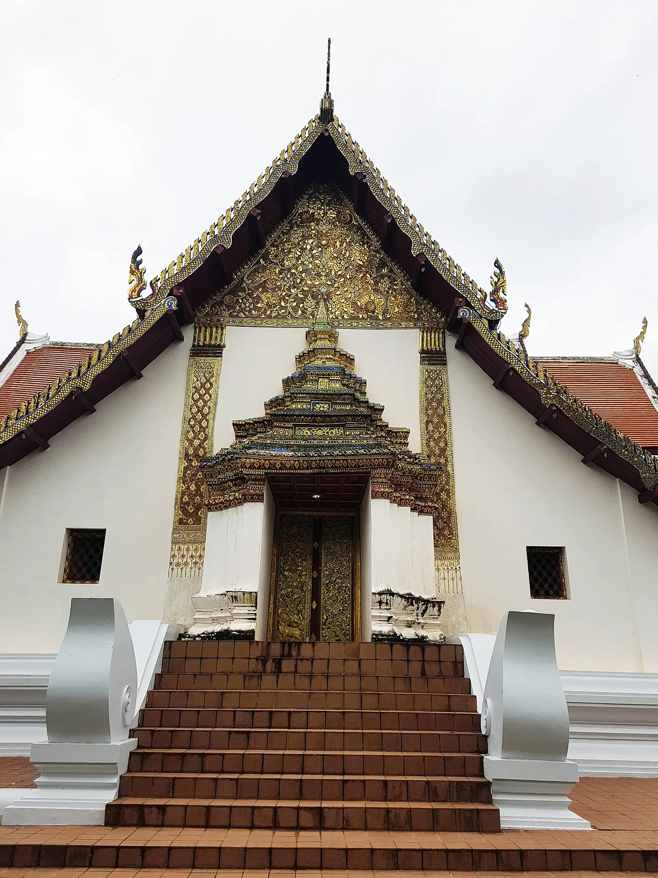 ประตูและหน้าจั่วปิดทองของวัดภูมินทร์ มองขึ้นไปจากบันไดอิฐ ภาพถ่ายจาก Wikimedia Commons