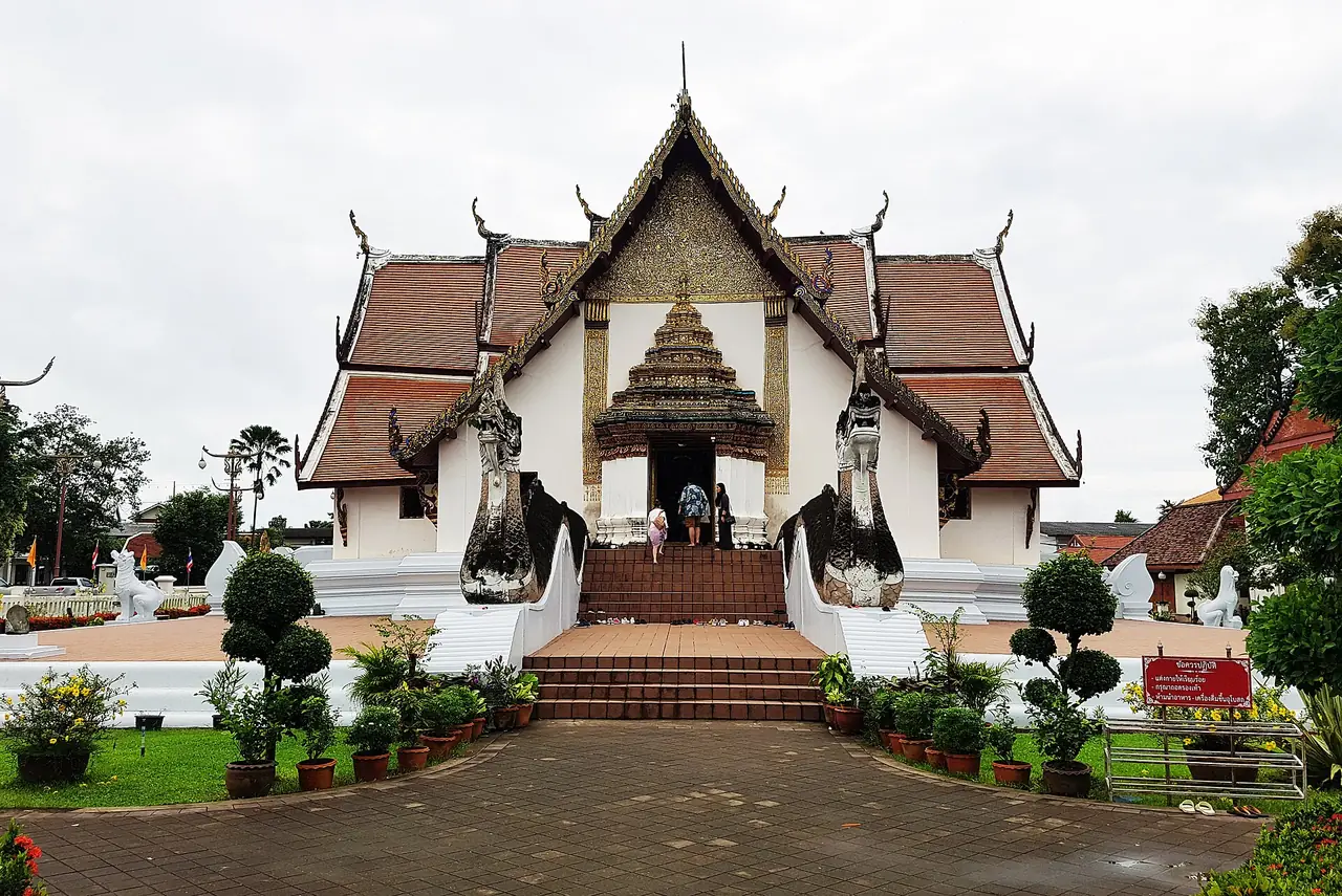 วัดภูมินทร์ที่น่าน วิหารสีขาวหลังคากระเบื้องแดงซ้อนชั้น มีรูปปั้นพญานาคข้างบันได