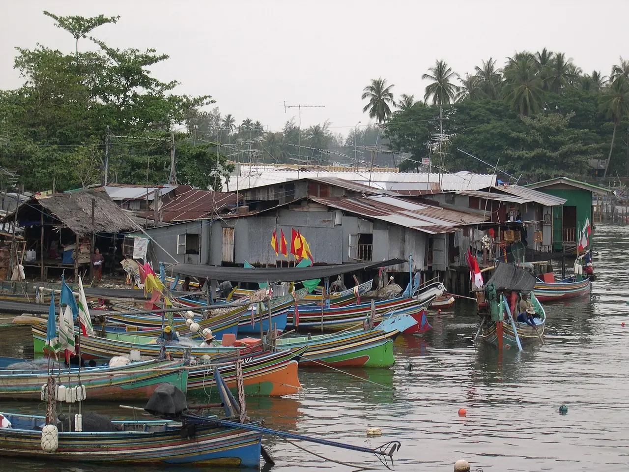 หมู่บ้านชาวประมงในจังหวัดนราธิวาส เรือประมงสีสันสดจอดเรียงริมน้ำ