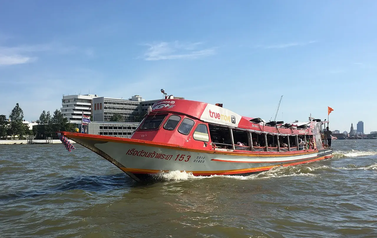 An orange-flag Chao Phraya Express Boat heading upriver to Nonthaburi