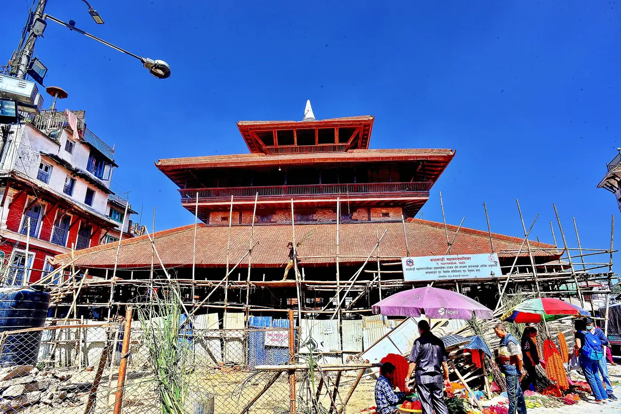 กัสถมณฑปในจัตุรัสทุรบาร์กาฐมาณฑุ เห็นนั่งร้านและตลาดริมทาง ภาพจาก Wikimedia Commons ผู้ถ่าย Rajesh Dhungana สัญญา CC BY-SA 4.0 ไม่ระบุปีที่ถ่ายในที่ที่เรามี