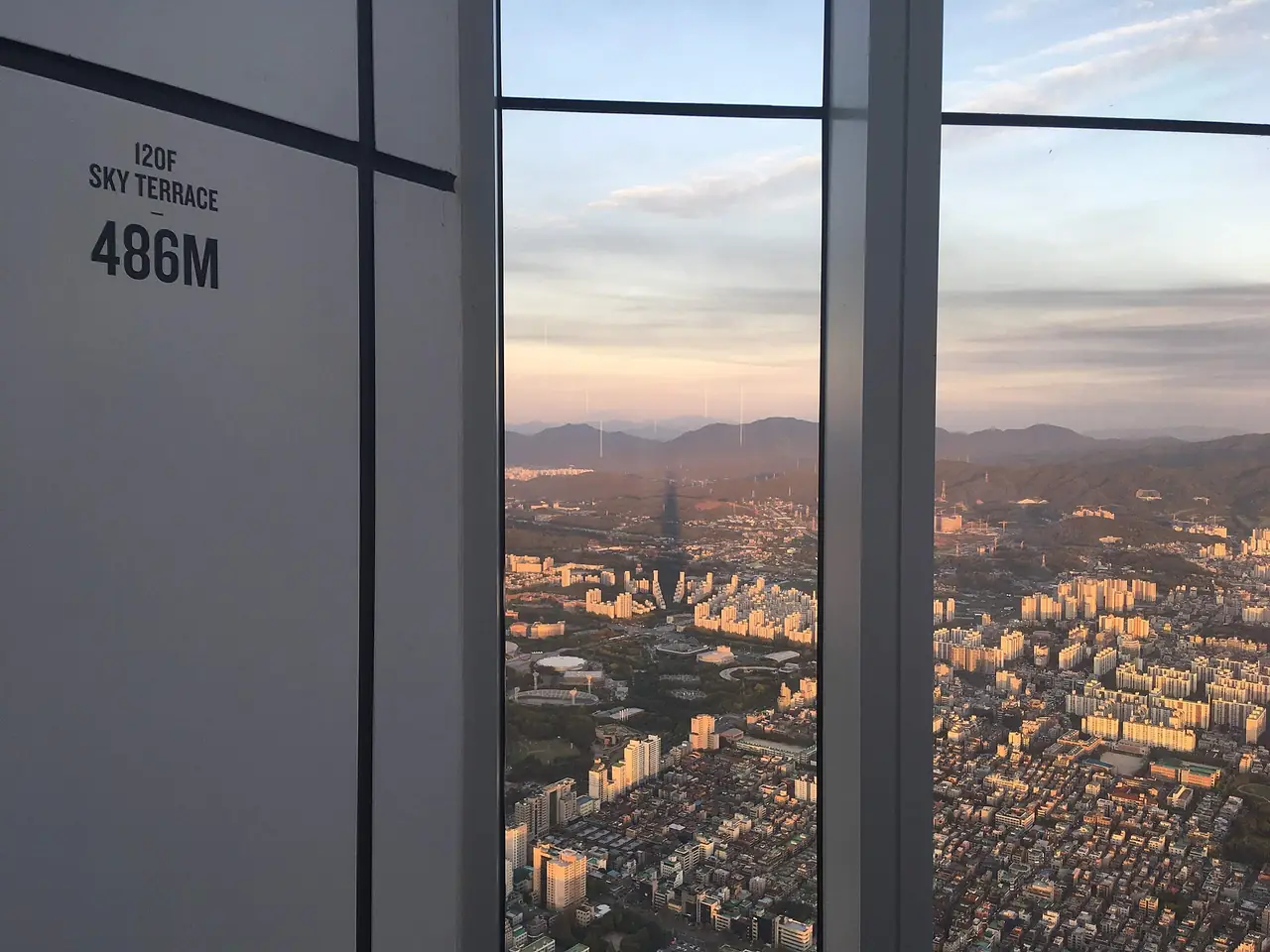 หน้าต่างที่ชั้น 120 ระเบียงฟ้า Seoul Sky ความสูง 486 เมตร มองเห็นเมืองโซลด้านล่าง