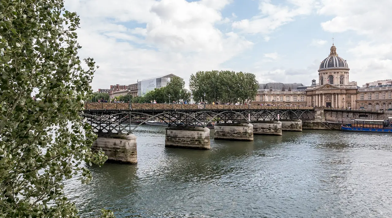 สะพาน Pont des Arts ข้ามแม่น้ำแซน มองไปทางสถาบันฝรั่งเศส ภาพถ่ายจาก Wikimedia Commons
