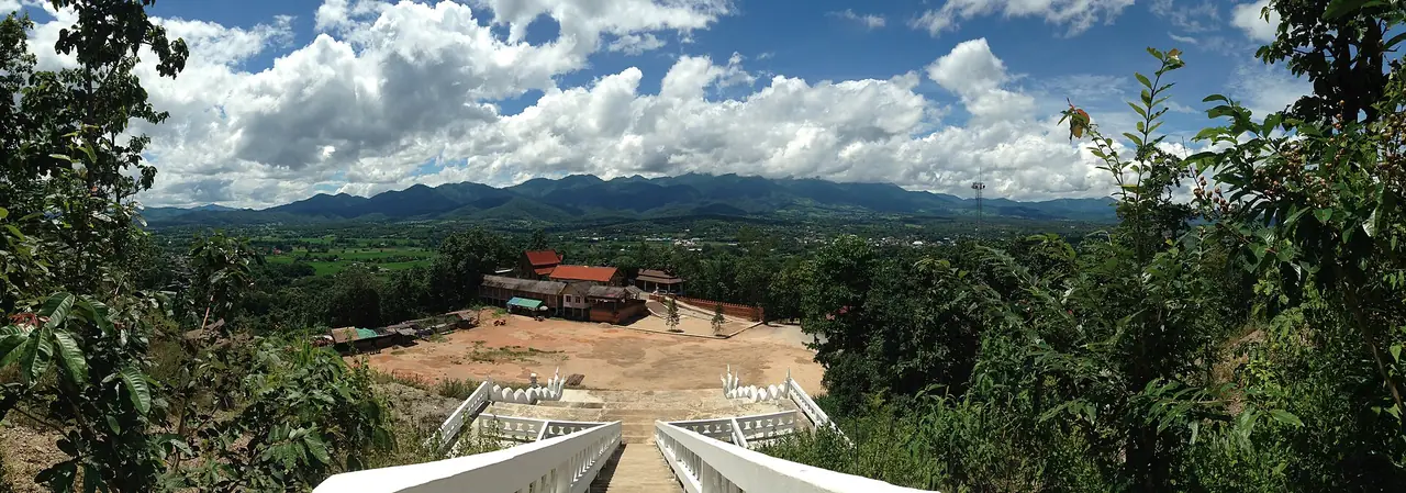 ภาพพาโนรามาจากบันไดพระใหญ่วัดพระธาตุแม่เย็น มองเห็นหุบเขาปายและทางลาดบันไดด้านล่าง ภาพจาก Wikimedia Commons ผู้ถ่าย ElonggnolE