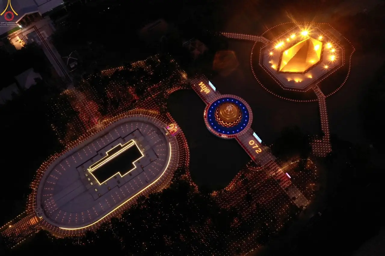ภาพมุมสูงของวัดพระธรรมกายตอนกลางคืน ภาพของ Farang Rak Tham จาก Wikimedia Commons ใบอนุญาต CC BY-SA 4.0 คำบรรยายบน Commons ว่าเป็นภาพมุมสูงของอุโบสถและอนุสรณ์สถานคุณยายอาจารย์