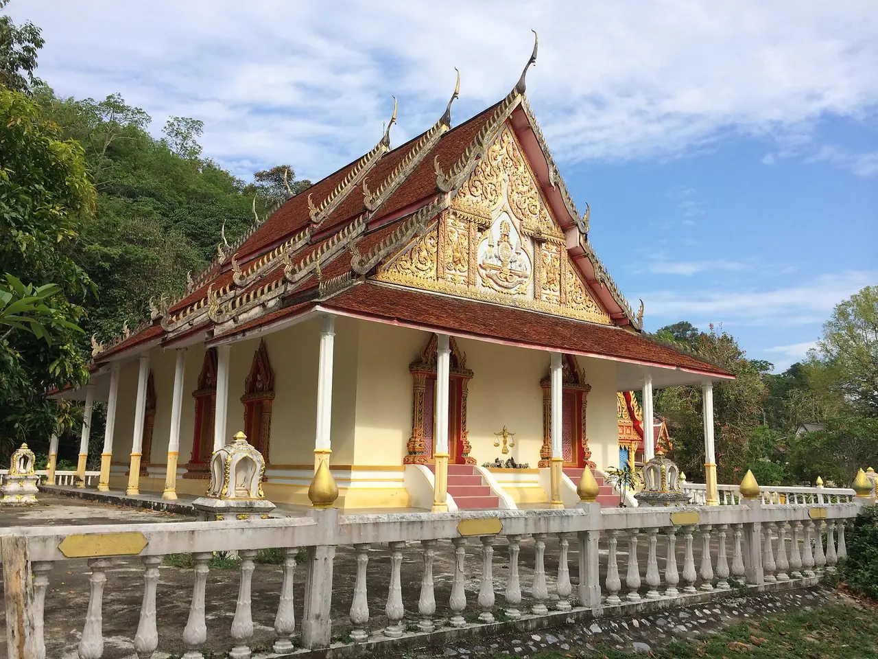 A temple among trees and hills in Taluban, Sai Buri district, from a Commons photo