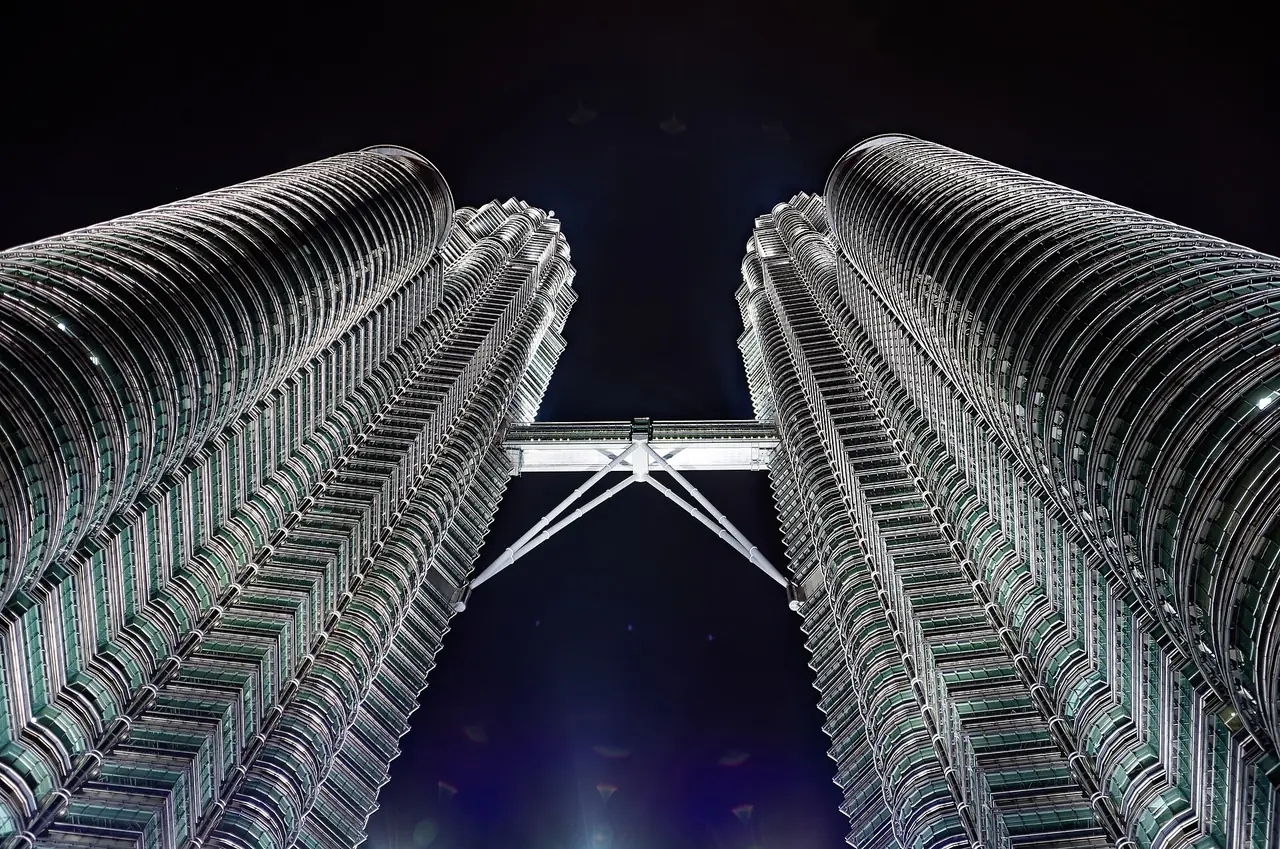 ตึกแฝด Petronas ยามค่ำ ถ่ายมองขึ้นจากฐานตึกเห็น SkyBridge