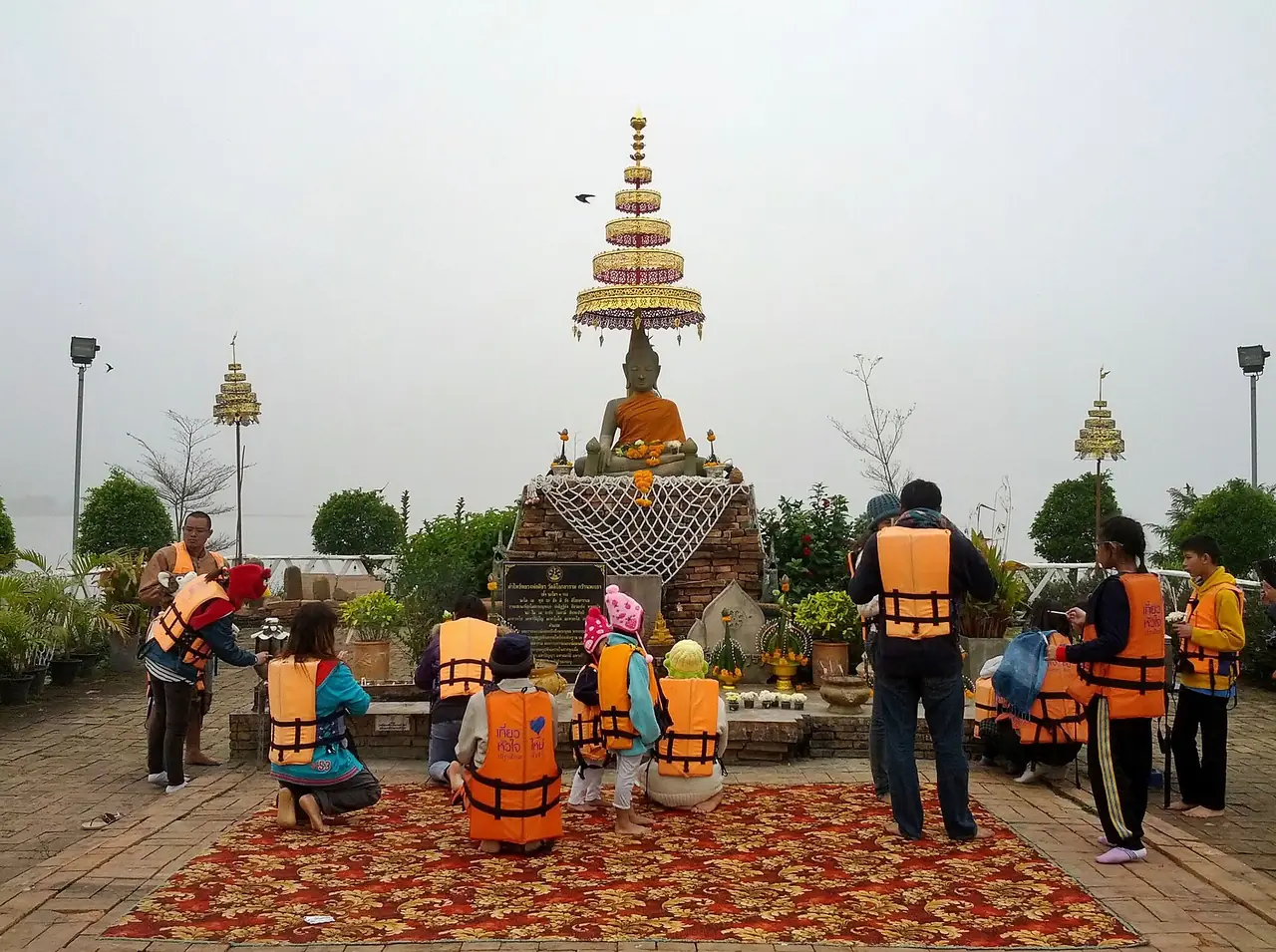 นักท่องเที่ยวสวมเสื้อชูชีพไหว้พระที่วัดติโลกอารามกลางกว๊านพะเยา