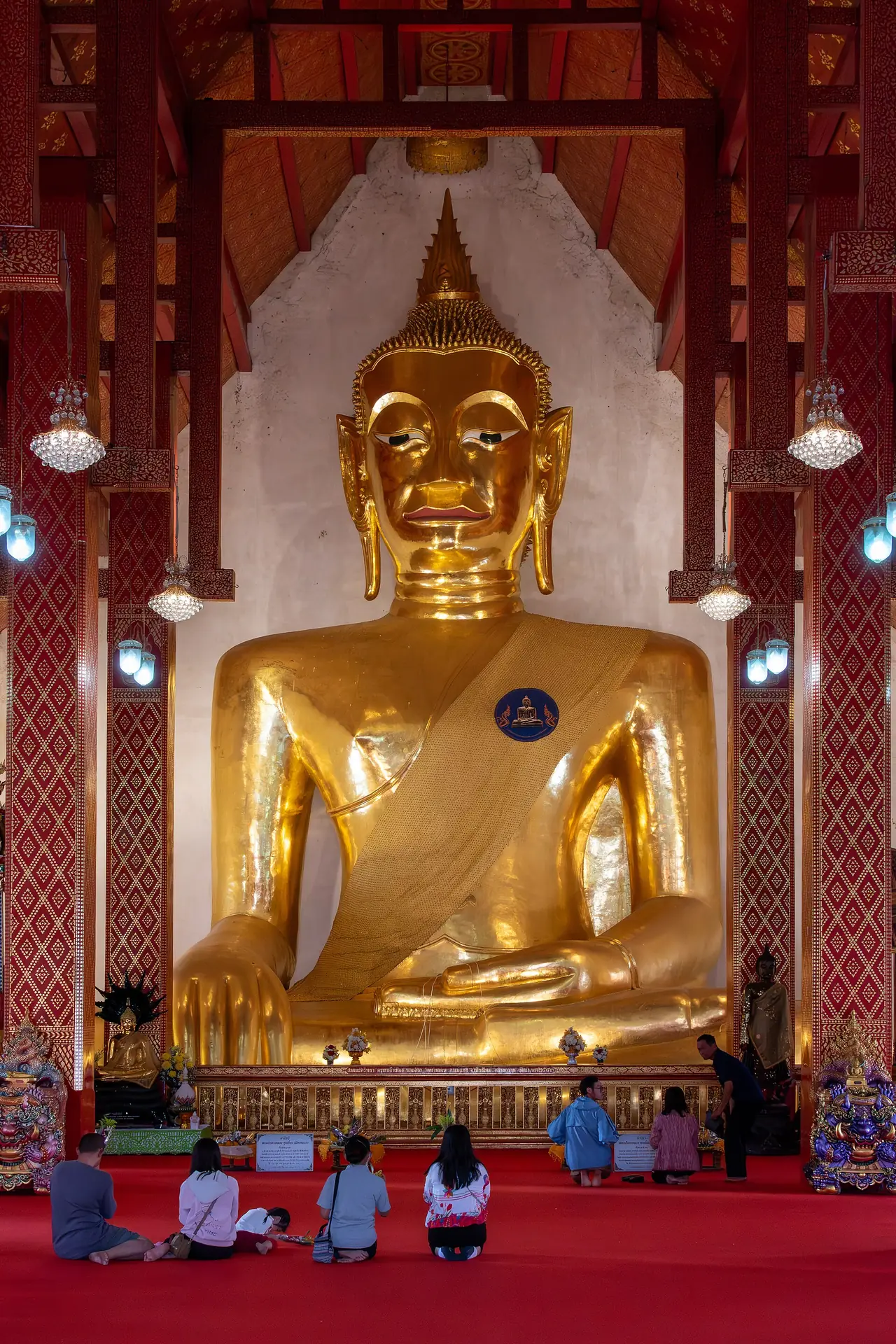 พระเจ้าตนหลวง พระประธานของวัดศรีโคมคำ ผู้คนนั่งกราบอยู่ด้านหน้า