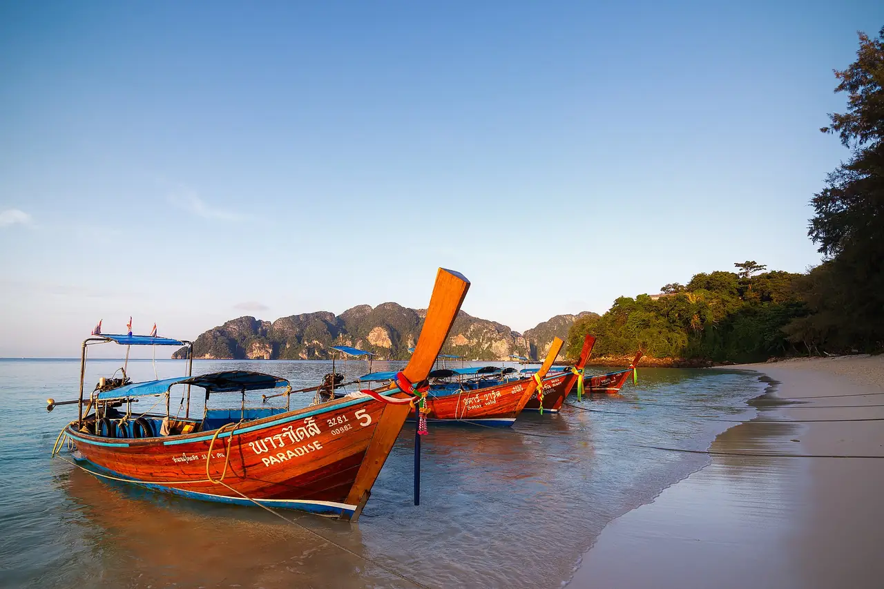 Longtail boats on the sand at Long Beach, Phi Phi Don, in warm evening light
